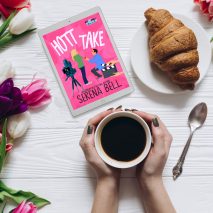 Flatlay image of tablet showing "Hott Take" book cover, tulip flowers on the left, a croissant in the upper right corner, and hands holding a cup of coffee