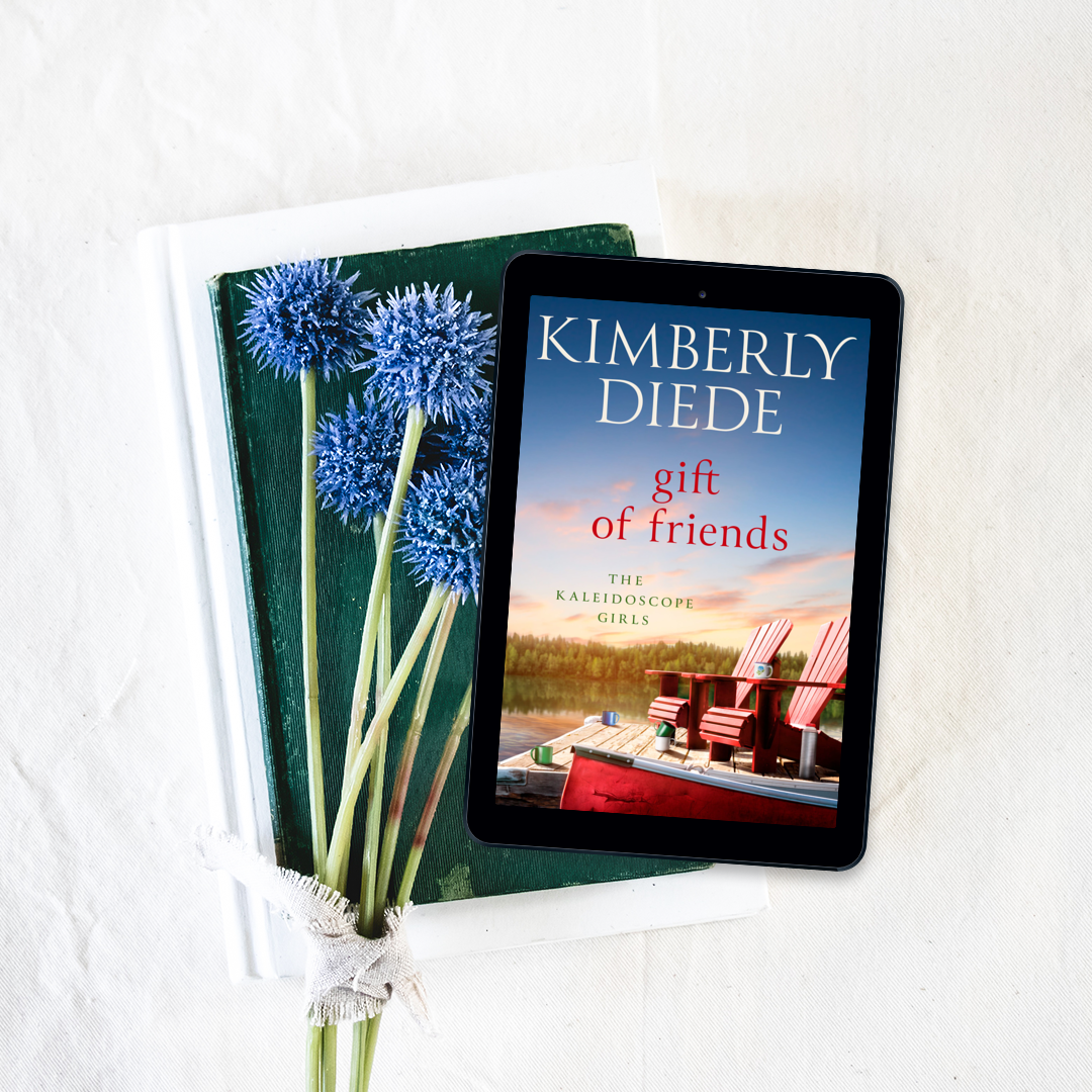 Flatlay image of a tablet showing the cover for "Gift of Friends" with flowers on the table.